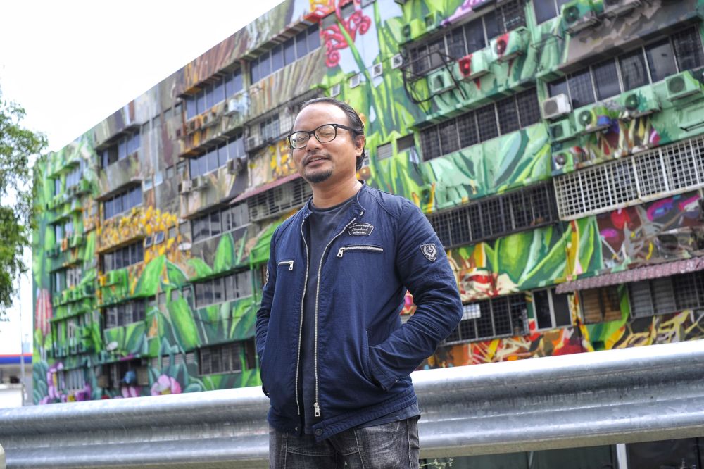 Artist Fadzlan Rizan Johani strikes a pose with his mural masterpiece in front of the Indah UPC building along Jalan Klang Lama, February 12, 2020. u00e2u20acu201d Picture by Shafwan Zaidon