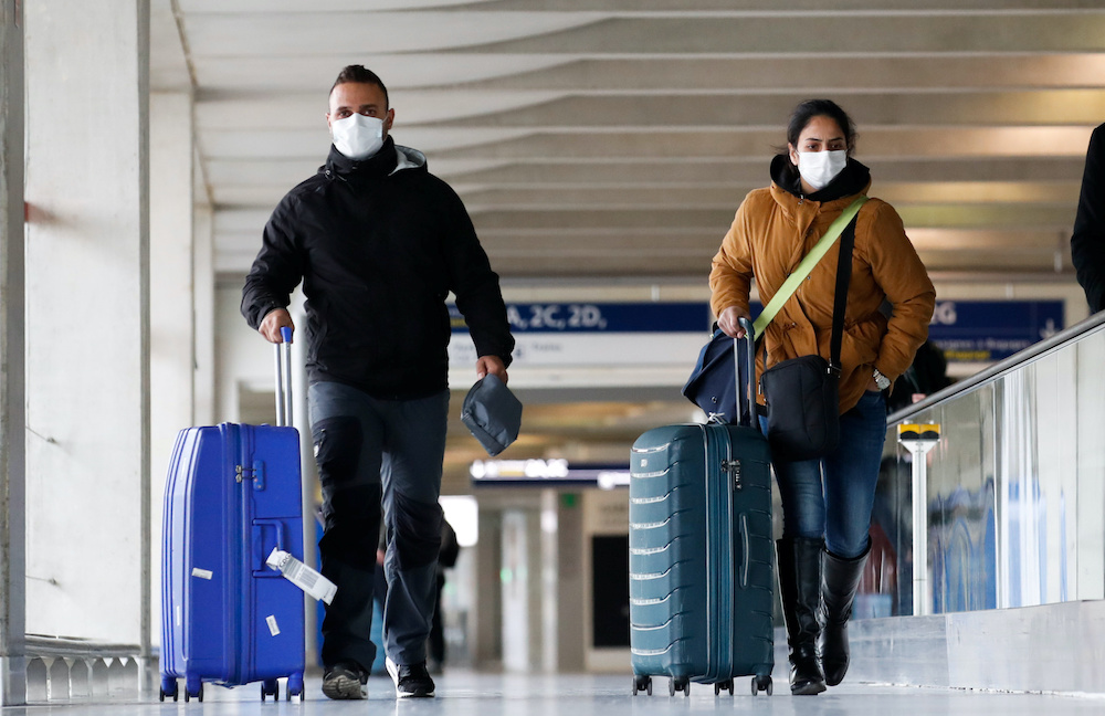 People wearing protective face masks walk as they arrive at Charles de Gaulle airport near Paris, France, as the coronavirus outbreak continues to expand, February 29, 2020. u00e2u20acu201d Reuters picnnnn