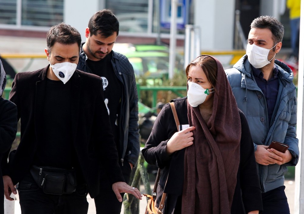 Iranians, some wearing protective masks, wait to cross a street in the capital Tehran on February 22, 2020. u00e2u20acu201d AFP pic