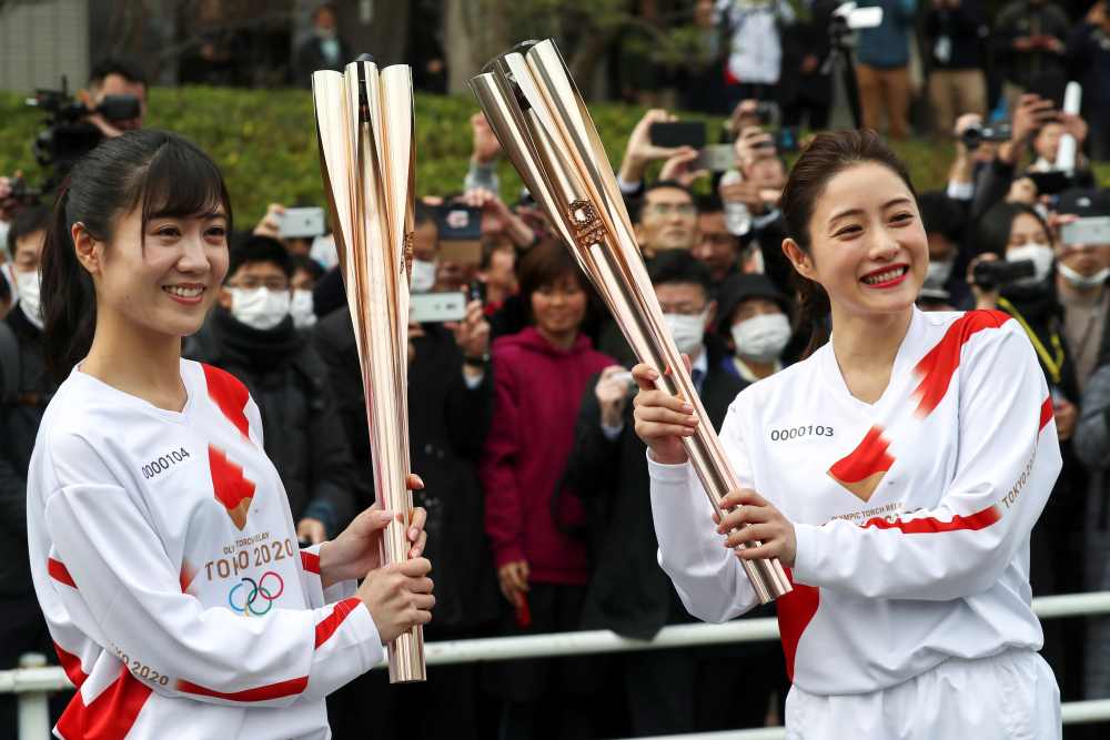 Acting torchbearer and Actress Satomi Ishihara (right), one of the Official Ambassadors of the Tokyo 2020 Torch Relay pose with the olympic torch during a rehearsal as part of the Tokyo 2020 Olympic Torch Relay in Hamura, outskirts of Tokyo February 15, 2