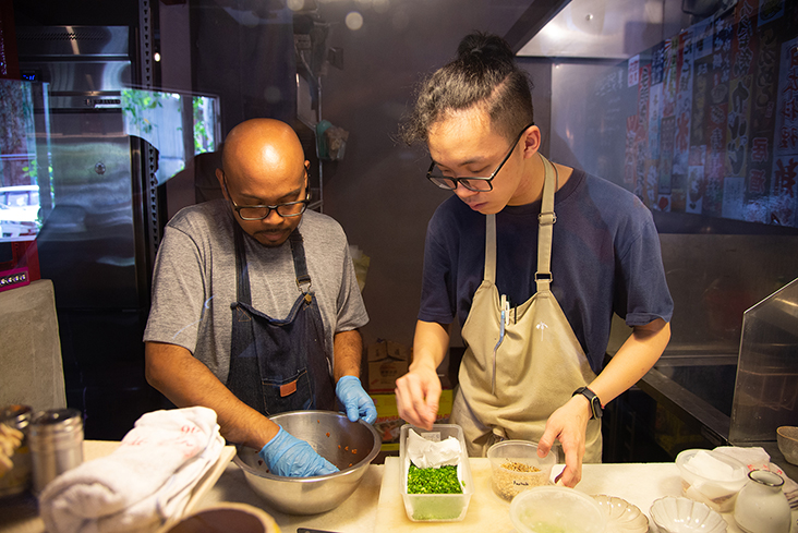 Kenneth Chu (left) preparing the food in Shokudo Niban's kitchen.