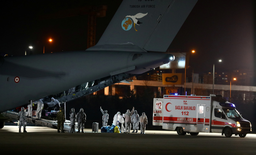 Turkish, Azeri and Georgian evacuees dressed in protective suits and wearing masks leave a Turkish military cargo plane as they are flanked by medical workers upon their arrival from Chinau00e2u20acu2122s Wuhan in Ankara, Turkey, February 1, 2020. u00e2u20acu201d Reuters pic 