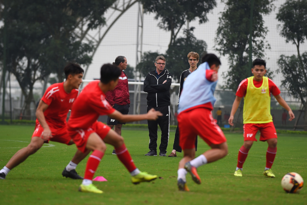 This photograph taken January 13, 2020 shows former French football player and technical director of the Promotion Fund of Vietnamese Football Talent (PVF) academy Philippe Troussier (centre) watching players during a training session at the PVF academy i
