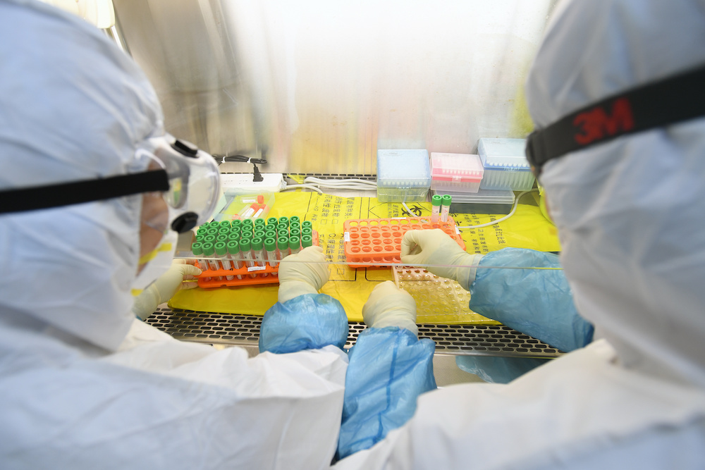 Workers in protective suits examine specimens inside a laboratory following an outbreak of the novel coronavirus in Wuhan, Hubei province, China February 6, 2020. u00e2u20acu201d Reuters picnn