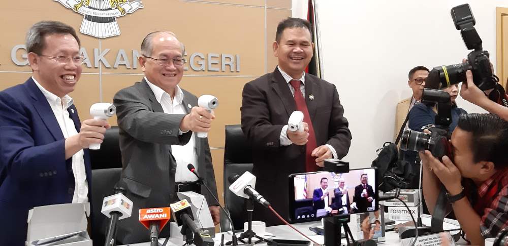 Deputy Chief Minister Datuk Amar Douglas Uggah (centre) showing the thermos guns that the state government will supply to the immigration checkpoints at the airports in the state, February 4, 2020. u00e2u20acu2022 Picture by Sulok Tawie