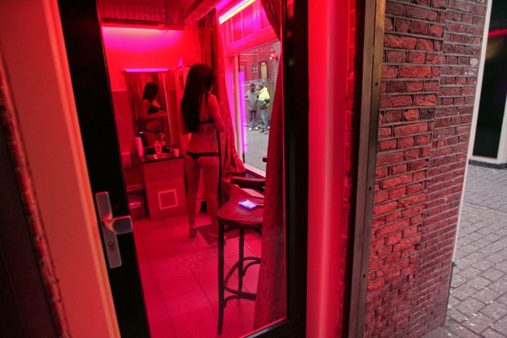 A prostitute waits for clients behind her window in the red light district of Amsterdam. u00e2u20acu201d AFP pic