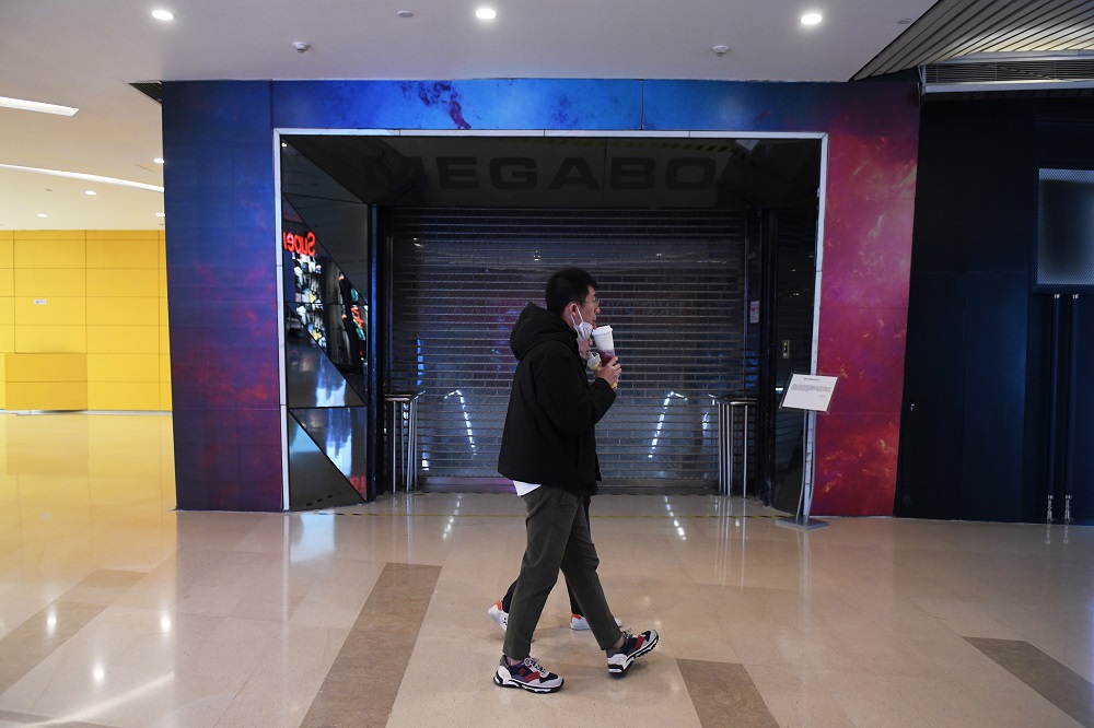 This photo taken on February 16, 2020 shows a couple walking past the closed Megabox cinema in Beijing. u00e2u20acu201d AFP pic 