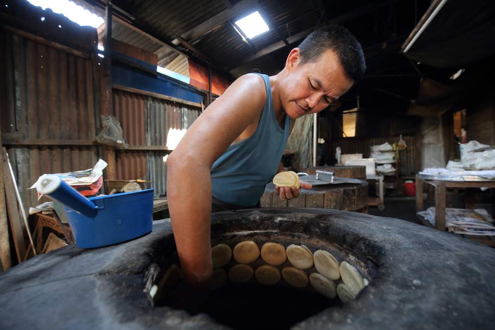 Keong Kee Heong Peng business owner Lew Yung Boon believes coconut husks give a savoury aroma to the biscuits and the oil produced gives the biscuits a distinctive taste. — Malay Mail pic