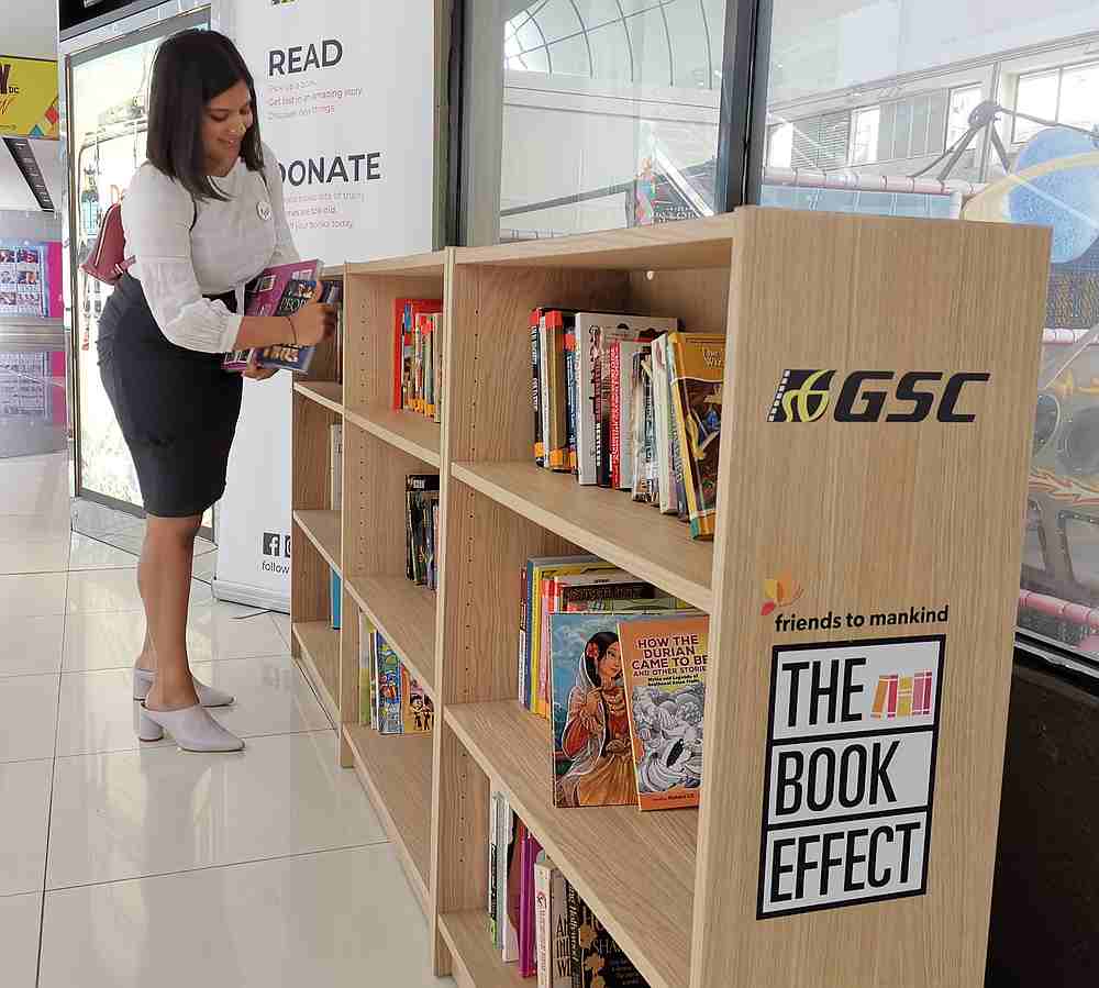 Friends to Mankind youth ambassador and project lead Apshy Vimal places a book on one of The Book Effect shelves located at GSC 1 Utama. u00e2u20acu201d Picture courtesy of GSC