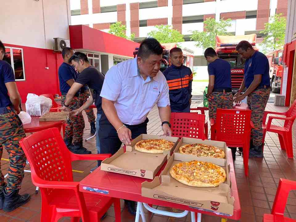 Tan lays out pizzas for the first responders who came to his aid. — Picture from Facebook/Balai Bomba Dan Penyelamat Taman Tun Dr Ismail Kuala Lumpur