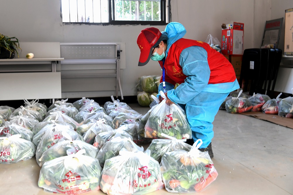 This photo taken on February 18, 2020 shows a community staff member carrying foods and daily necessities as she prepares to deliver for residents in Wuhan in China's central Hubei province. u00e2u20acu201d AFP pic