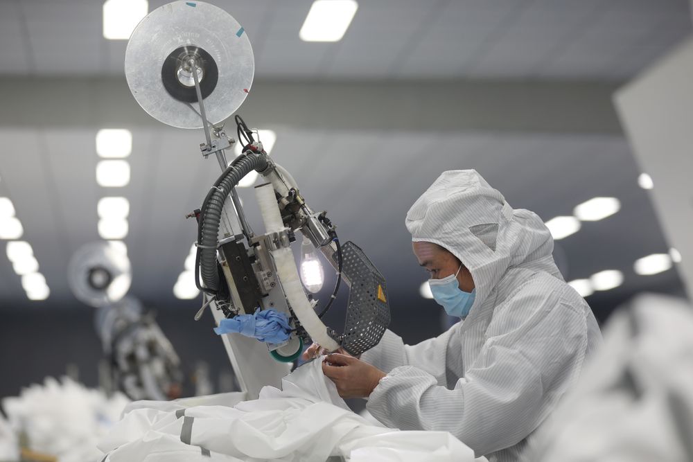 An employee works on a production line manufacturing protective suits at a medical supply factory in Xinzhou district of Wuhan, the epicentre of the novel coronavirus outbreak, in Hubei province, China, February 12, 2020. u00e2u20acu201d China Daily pic via Reuters