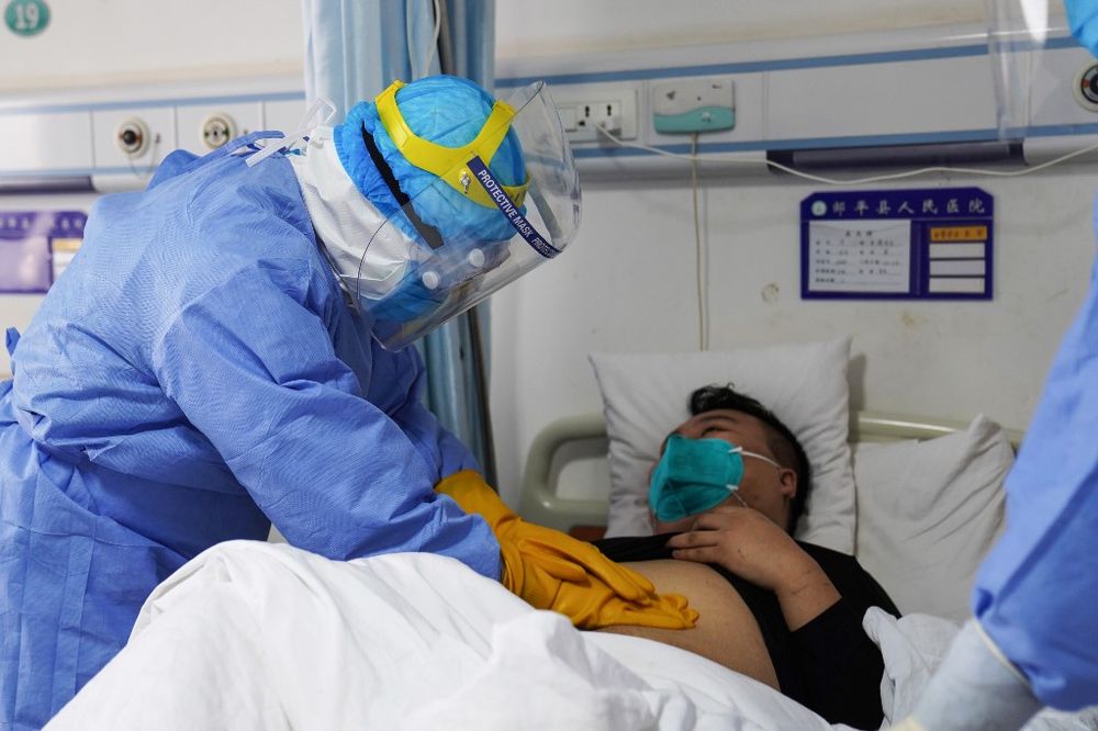 This photo taken on January 28, 2020 shows a medical staff member checking a patient infected by the novel coronavirus inside an isolation ward at a hospital in Zouping in Chinau00e2u20acu2122s eastern Shandong province. u00e2u20acu201d AFP pic