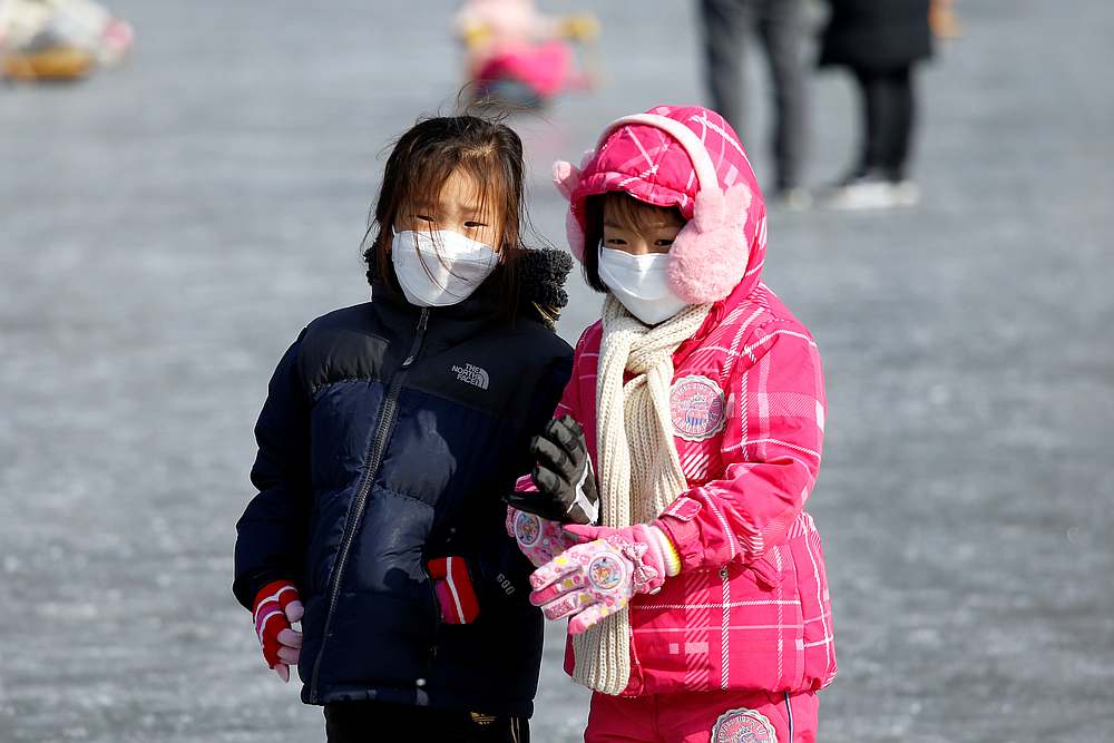 Children wearing masks to prevent contacting Covid-19 on a frozen river during the Ice Festival in Hwacheon,  South Korea, February 8, 2020. u00e2u20acu201d Reuters pic