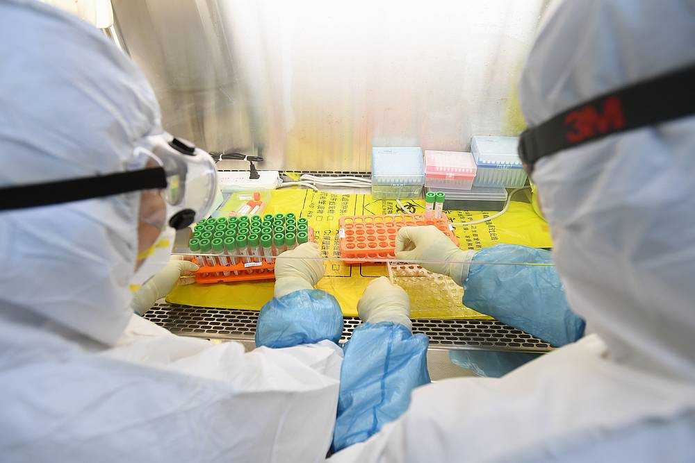 Workers in protective suits examine specimens inside a laboratory following an outbreak of the novel coronavirus in Wuhan, Hubei province, China February 6, 2020. u00e2u20acu201d China Daily pic via Reutersn