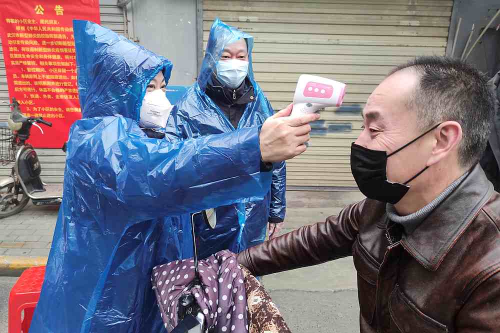A worker takes body temperature reading of a man at the entrance to a residential compound in Wuhan, Hubei province, China February 1, 2020. u00e2u20acu201d China Daily pic via Reuters