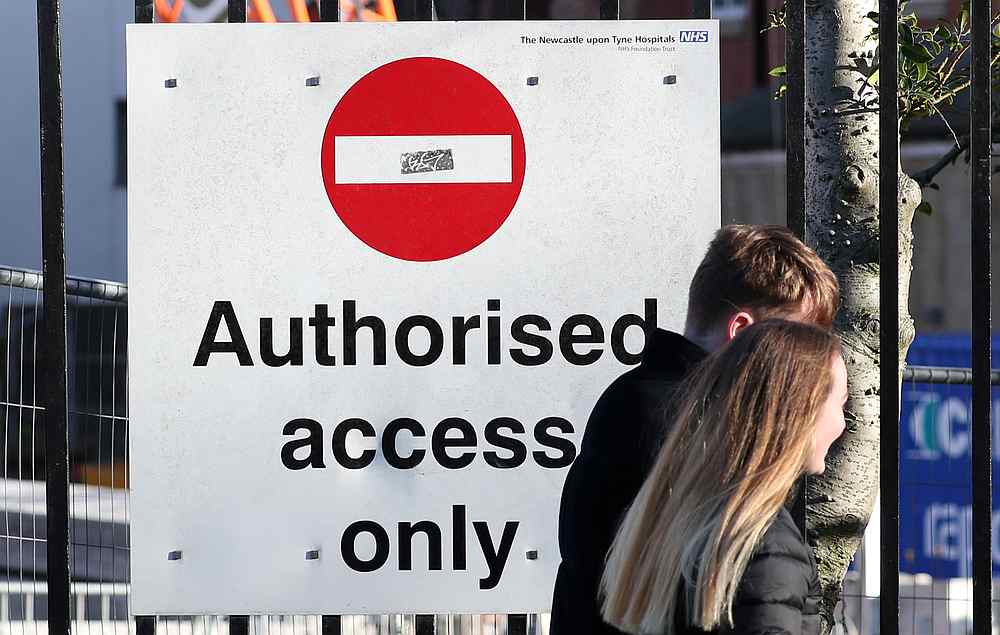 A couple pass a sign outside the Royal Victoria Infirmary, where two confirmed coronavirus patients are being treated, in Newcastle, Britain February 1, 2020. u00e2u20acu201d Reuters pic