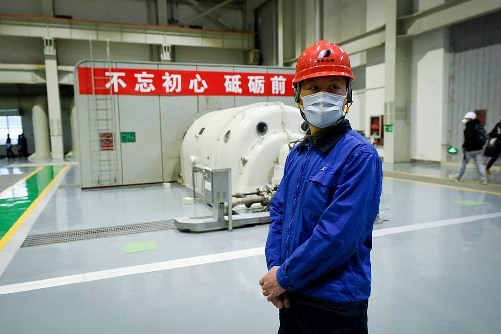 A worker wearing a face mask watches at a workshop during a visit organised by the government at Beijing Huadian Bjgas Energy Corporation February 27, 2020. u00e2u20acu201d AFP pic