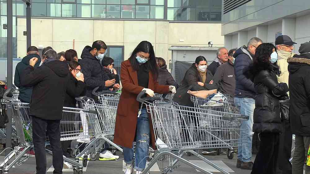 A crowd of Italians wearing protective masks wait outside a closed supermarket in the town of Casalpusterlengo, Italy February 23, 2020. u00e2u20acu201d Local team/Reuters TV image