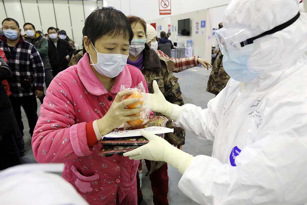 A patient receives lunch from a medical worker inside the Wuhan Parlor Convention Centre that has been converted into a makeshift hospital in Hubei province, China February 15, 2020. u00e2u20acu201d China Daily pic via Reuters