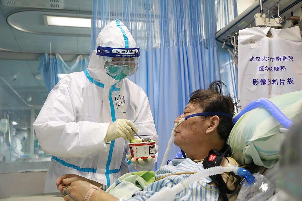 A nurse in a protective suit feeds a novel coronavirus patient inside an isolated ward at Zhongnan Hospital of Wuhan University, Hubei province, China February 8, 2020. u00e2u20acu201d China Daily pic via Reuters