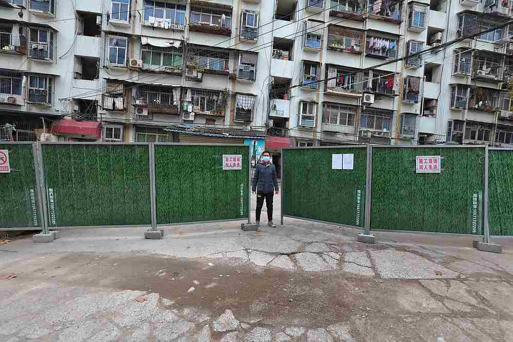 A man wearing a face mask keeps watch at an entrance to a residential community that has been fenced in with temporary barriers, in Yichang city of Hubei, China February 10, 2020. u00e2u20acu201d China Daily pic via Reuters