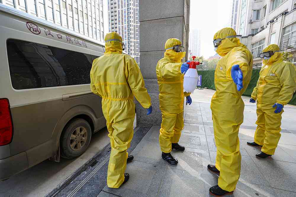 Funeral parlour staff members in protective suits help a colleague with disinfection after they transferred a body at a hospital in Wuhan, Hubei province, China January 30, 2020. u00e2u20acu201d China Daily pic via Reuters