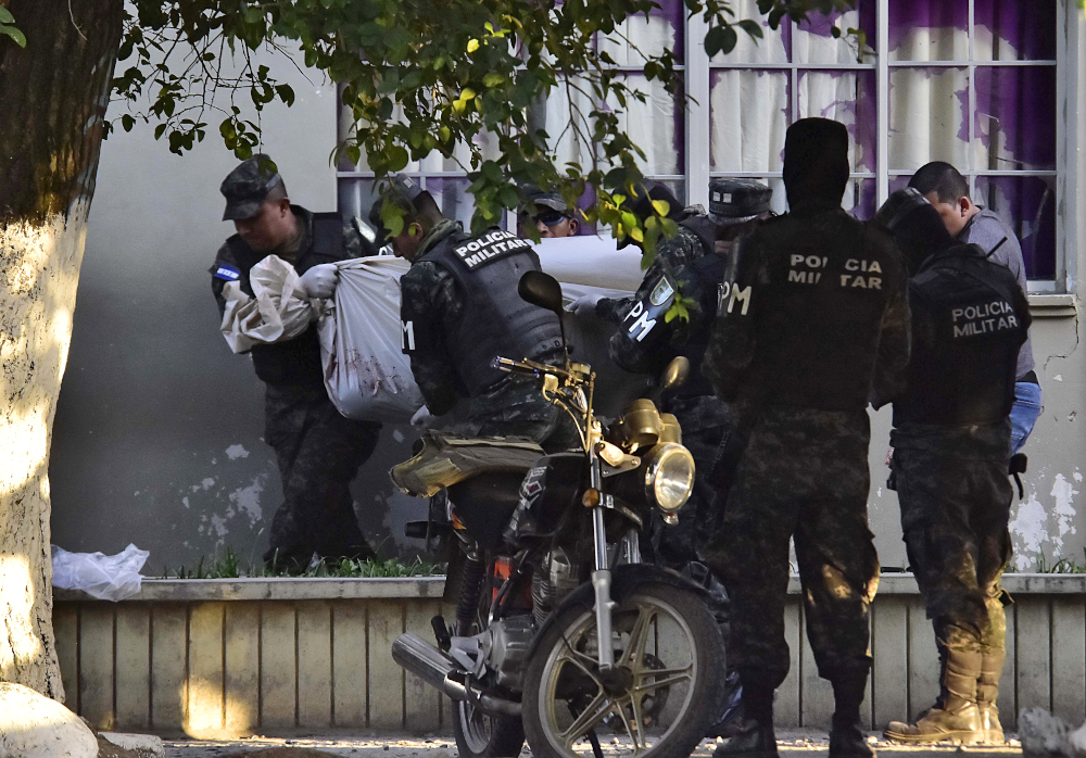 Agents of the Honduran Military Police of Public Order carry the corpse of a colleague outside the Justice Palace after the escape of Honduran Mara Salvatrucha (MS-13) gang leader Alexander Mendoza in El Progreso, Yoro department, Honduras February 13, 20