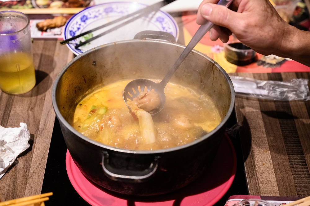 In this photo taken on February 11, 2020, a customer spoons out some food as he eats with a group of friends at 66 Hotpot, a family-run restaurant in the bustling district of Mongkok in Hong Kong. u00e2u20acu201d AFP pic
