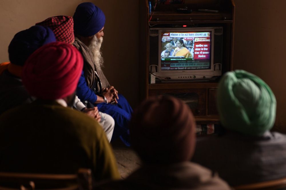 Farmers watch a news channel broadcasting India's Finance Minister Nirmala Sitharaman (centre on screen) presenting the 2020 union budget, at a village on the outskirts of Amritsar on February 1, 2020. u00e2u20acu201d AFP pic