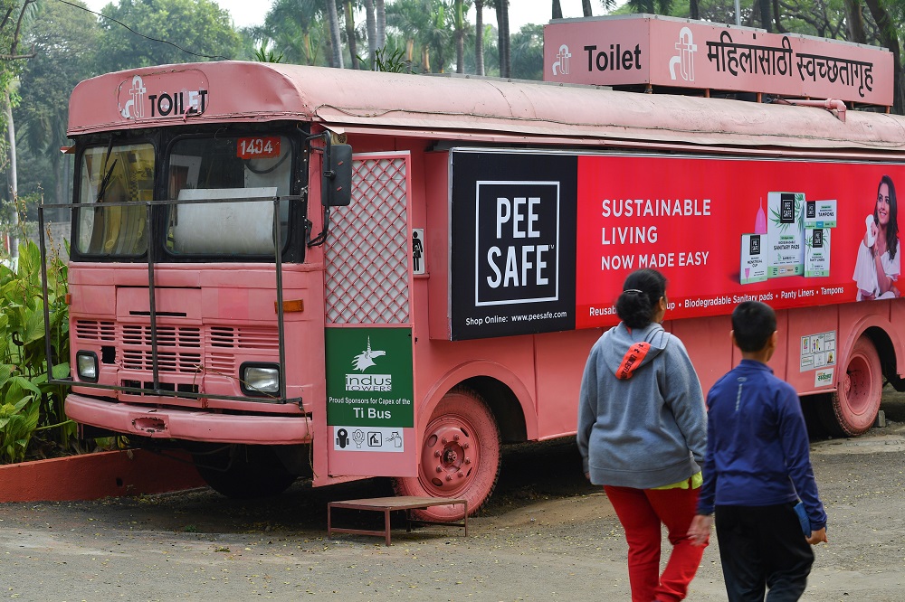 This photo taken on February 9, 2020 shows people walking past a mobile toilet on a bus at a public park in Pune. u00e2u20acu201d AFP pic