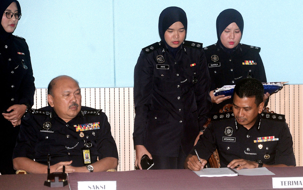 Johor Police chief Datuk Mohd Kamarudin Md Din witnesses ACP Mohd Afzanizam Yahaya signing his letter of appointment at the Johor Contingent Police Headquarters in Johor Baru February 3, 2020. u00e2u20acu201d Bernama pic
