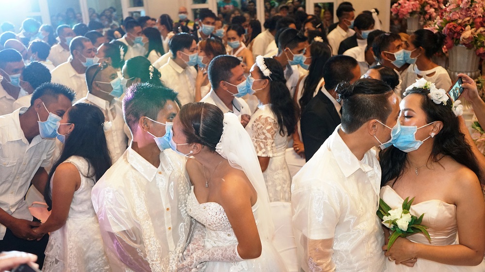 Filipino couples kiss while wearing their face masks in a government-sponsored mass wedding in Bacolod City, Philippines February 20, 2020. u00e2u20acu201d Bacolod City Public Information Office/Handout via Reuters