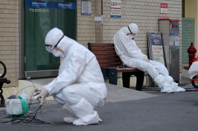 A medical worker takes a rest outside a hospital in Daegu, South Korea, February 23, 2020. u00e2u20acu201d Yonhap picture via Reuters