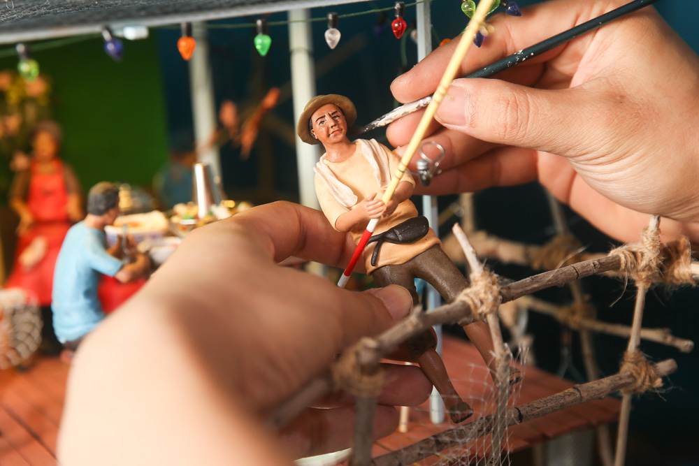 Putting the final touches on a fisherman for the ‘kelong’ (fishing resort) scene. — Picture by Choo Choy May