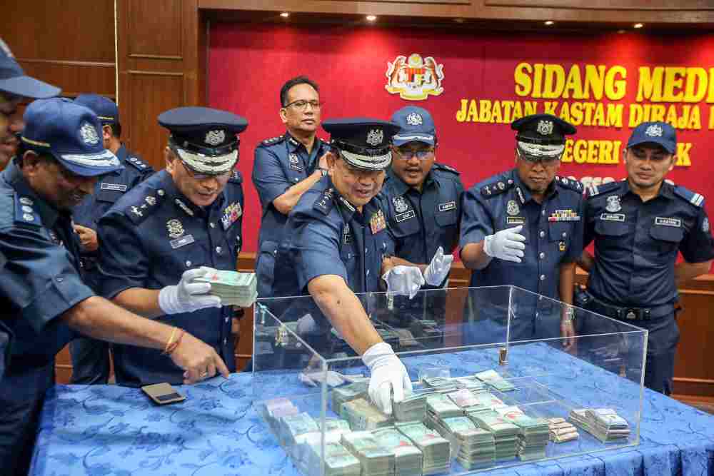 Perak Customs director Mohamad Sarpin showing the RM500,000 seized last Firday from three women who attempted to smuggle the money into Malaysia via the Pengkalan Hulu border. u00e2u20acu2022 Picture by Farhan Najib