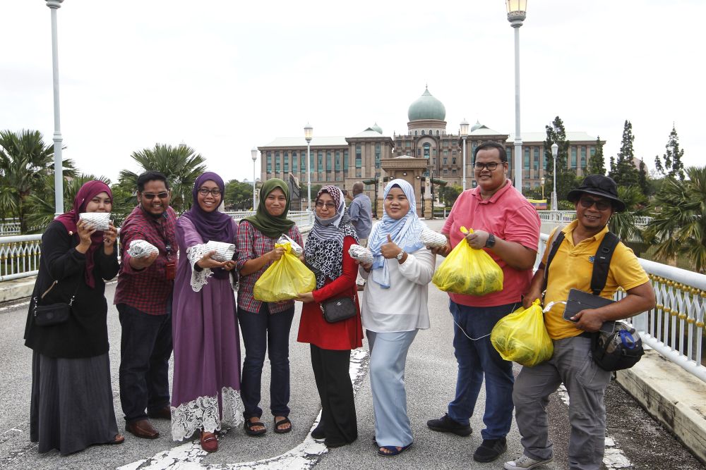 Nasi Lemak Royale representatives distribute packets of nasi lemak to members of the media outside Perdana Putra February 25, 2020. ― Picture by Shafwan Zaidon