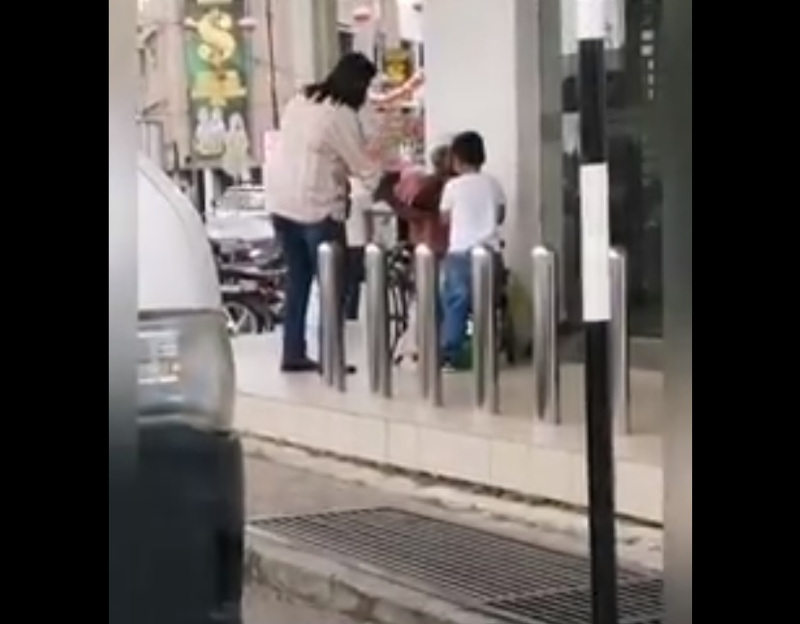 Little Fatih hands the hungry man a packet of food outside a Maybank in Nibong Tebal. u00e2u20acu201d Screengrab from Facebook/Penang Kini