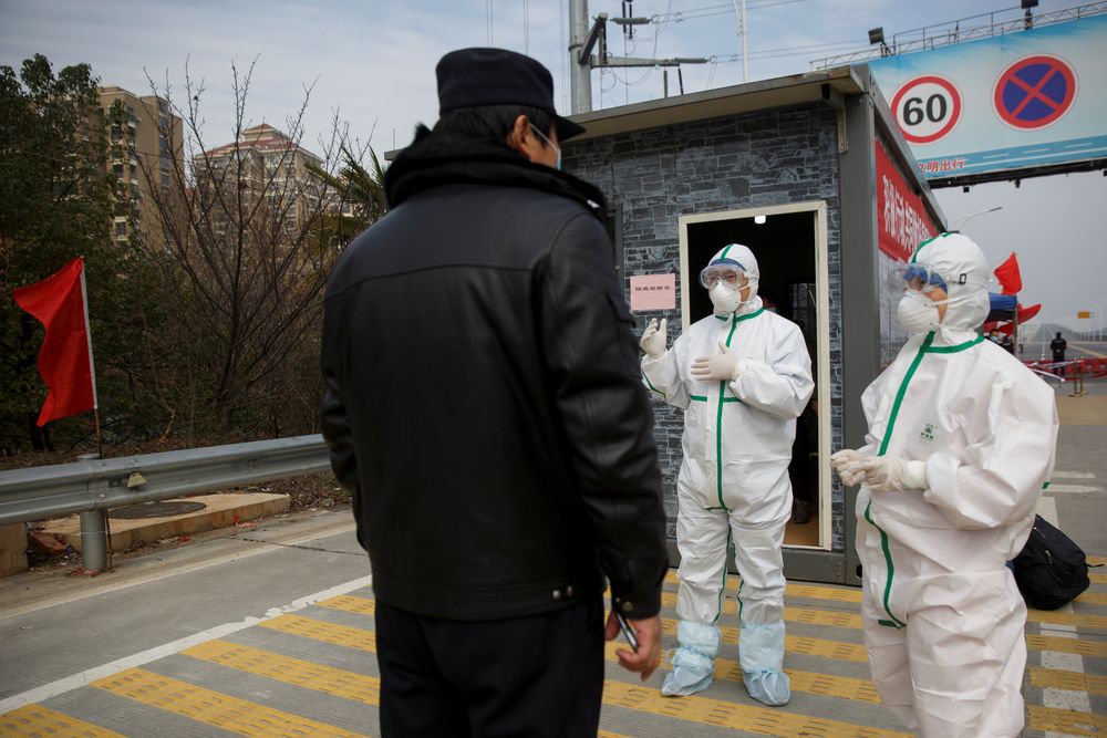 Hospital staff in protective garments talk to a police officer at a checkpoint to the Hubei province exclusion zone at the Jiujiang Yangtze River Bridge in Jiujiang, Jiangxi province, China, February 1, 2020. u00e2u20acu201d Reuters pic