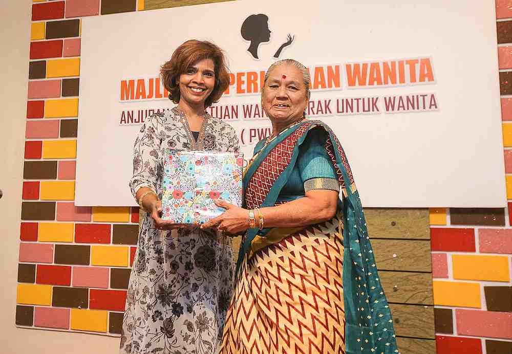 Kueh seller J. Angeline Phillip (right) receiving a momento from Perak Women for Women society president Sumathi Sivamany after a recent networking session organised by the society. u00e2u20acu201d Picture by Farhan Najib