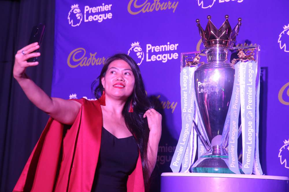 An excited member of the media  taking photos with the EPL trophy. — Picture by Choo Choy May