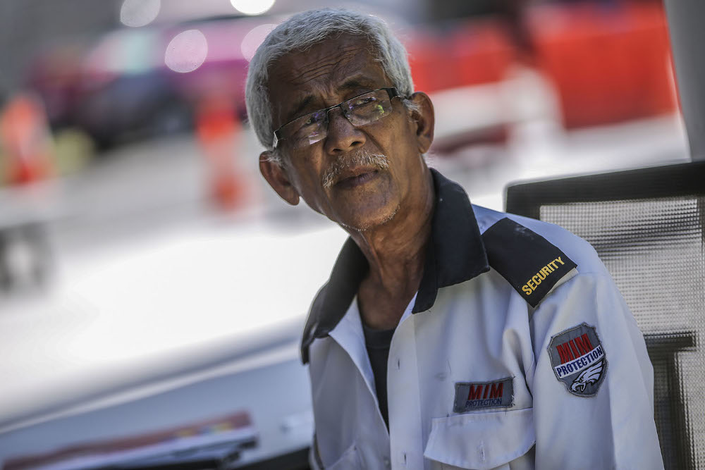 Security guard Sabarudin Kasim says the area around the bridge has become a hub of activity at night with visitors eager to snap pictures of the colourful lights. — Picture by Hari Anggara