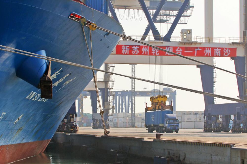 A crane lifts a container from a truck next to a cargo vessel at a port in Yantai, Shandong province, China October 17, 2019. u00e2u20acu201d Reuters pic