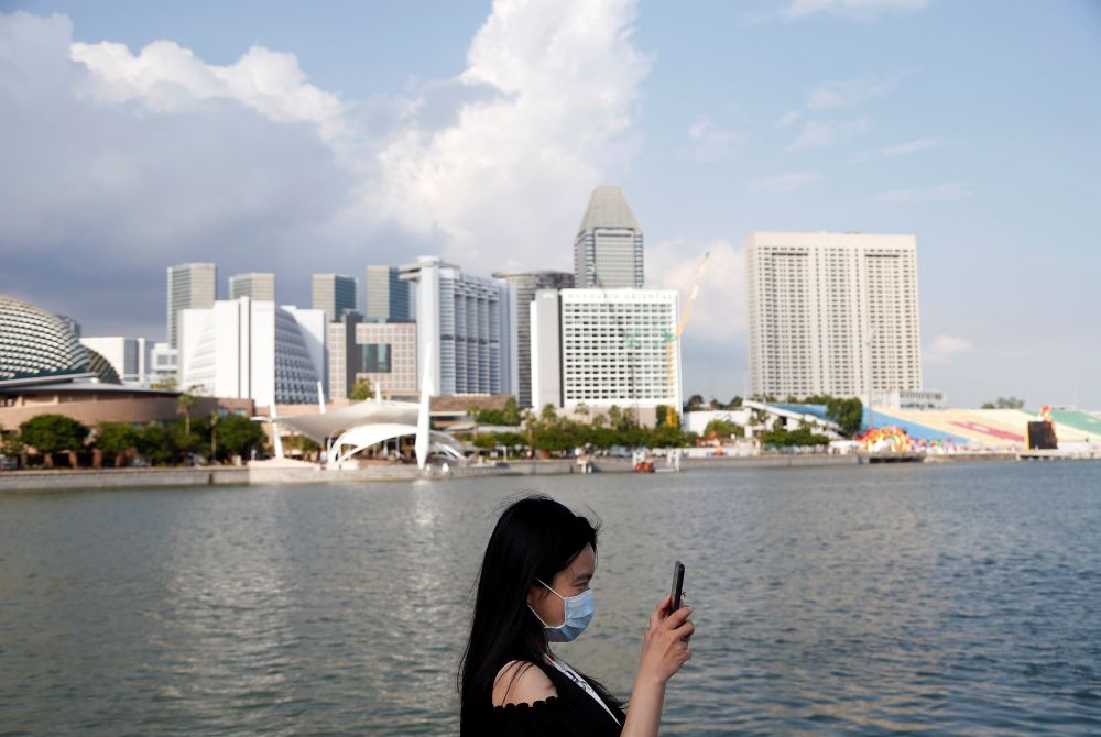 A tourist wearing a protective face mask takes photos at the Merlion Park in Singapore January 28, 2020. u00e2u20acu201d Reuters pic