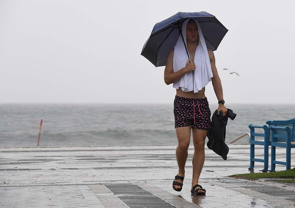 A pedestrian holds an umbrella during heavy rain in Coogee, Sydney, Australia February 7, 2020. u00e2u20acu201d AAP Image/Peter Rae pic via Reuters