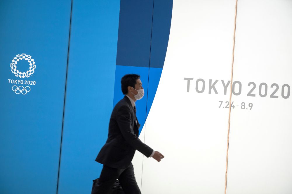 A man wearing a protective face mask, following an outbreak of the coronavirus, walks past an advertising billboard of Tokyo Olympics 2020, near the Shinjuku station in Tokyo February 27, 2020. u00e2u20acu201d Reuters pic 