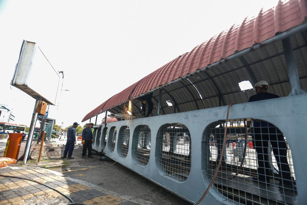 Penang Island Municipal Council staff dismantle the damaged pedestrian bridge at Weld Quay February 6, 2020. — Picture by Sayuti Zainudin