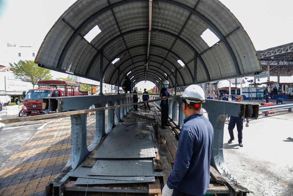 Penang Island Municipal Council staff dismantle the damaged pedestrian bridge at Weld Quay February 6, 2020. u00e2u20acu201d Picture by Sayuti Zainudin