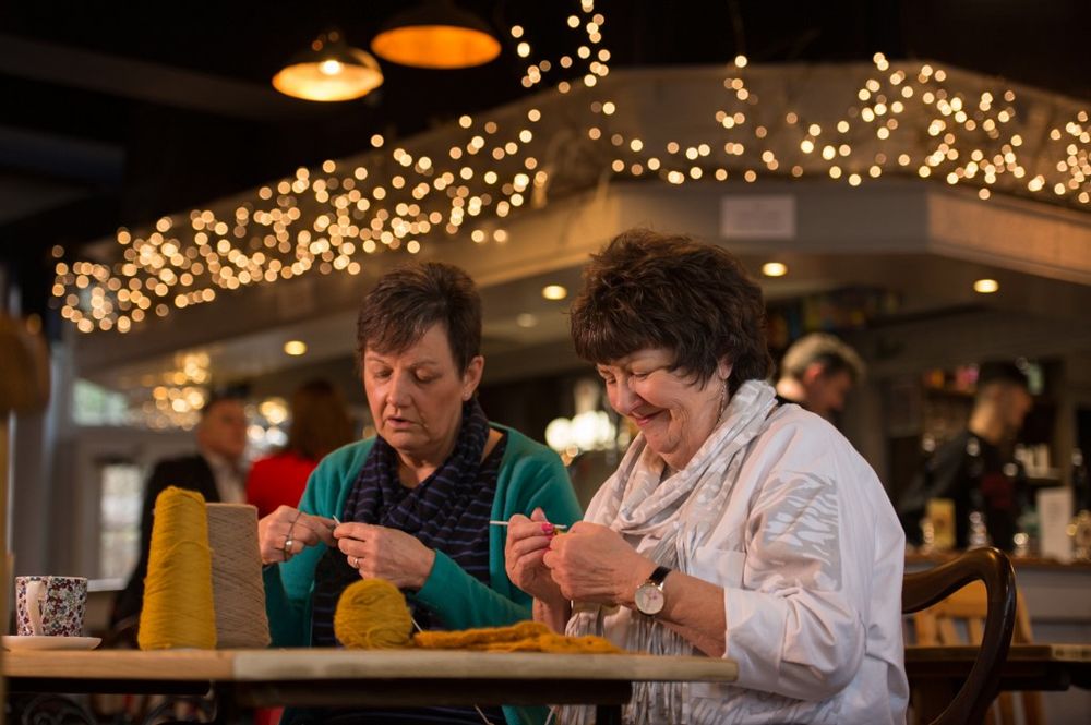 Members of the Yarn Group Liz Smith (right) and Jackie Candlish knit in the bar area of the community-owned Ye Olde Cross pub in Ryton village, near Newcastle upon Tyne, in north east England on February 5, 2020. — AFP pic