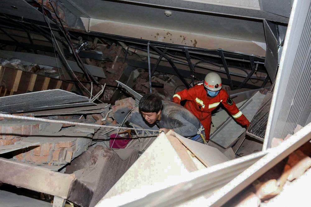 A man is helped by rescuers as he is pulled from the rubble of a collapsed hotel in Quanzhou March 7, 2020. u00e2u20acu201d AFP pic